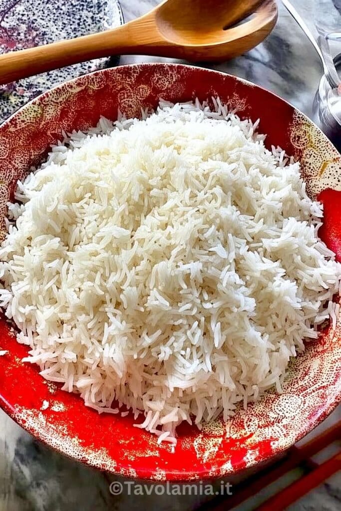 Riso basmati cottura: guida pratica e tecniche perfette 1 Riso basmati cotto, servito soffice in ciotola rossa decorativa