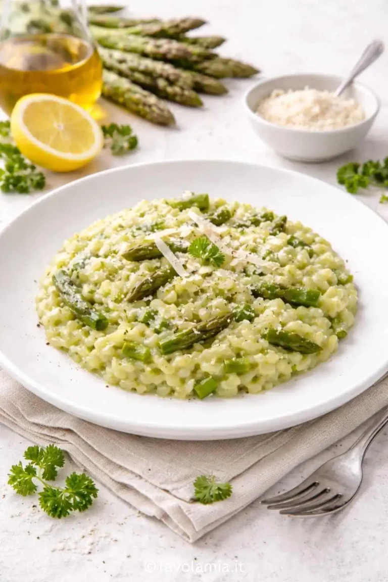Risotto asparagi cremoso impiattato con punte di asparagi e Parmigiano