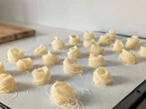 Nidi dolci di kataifi crudi disposti su una teglia