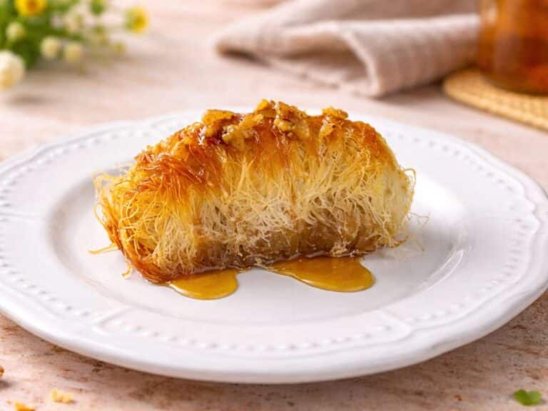 Kataifi ricetta greca cotto al forno, dolce tradizionale con pasta kataifi croccante, noci e sciroppo servito su piatto bianco