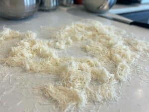 Pasta kataifi sfilacciata e pronta su un piano di lavoro moderno